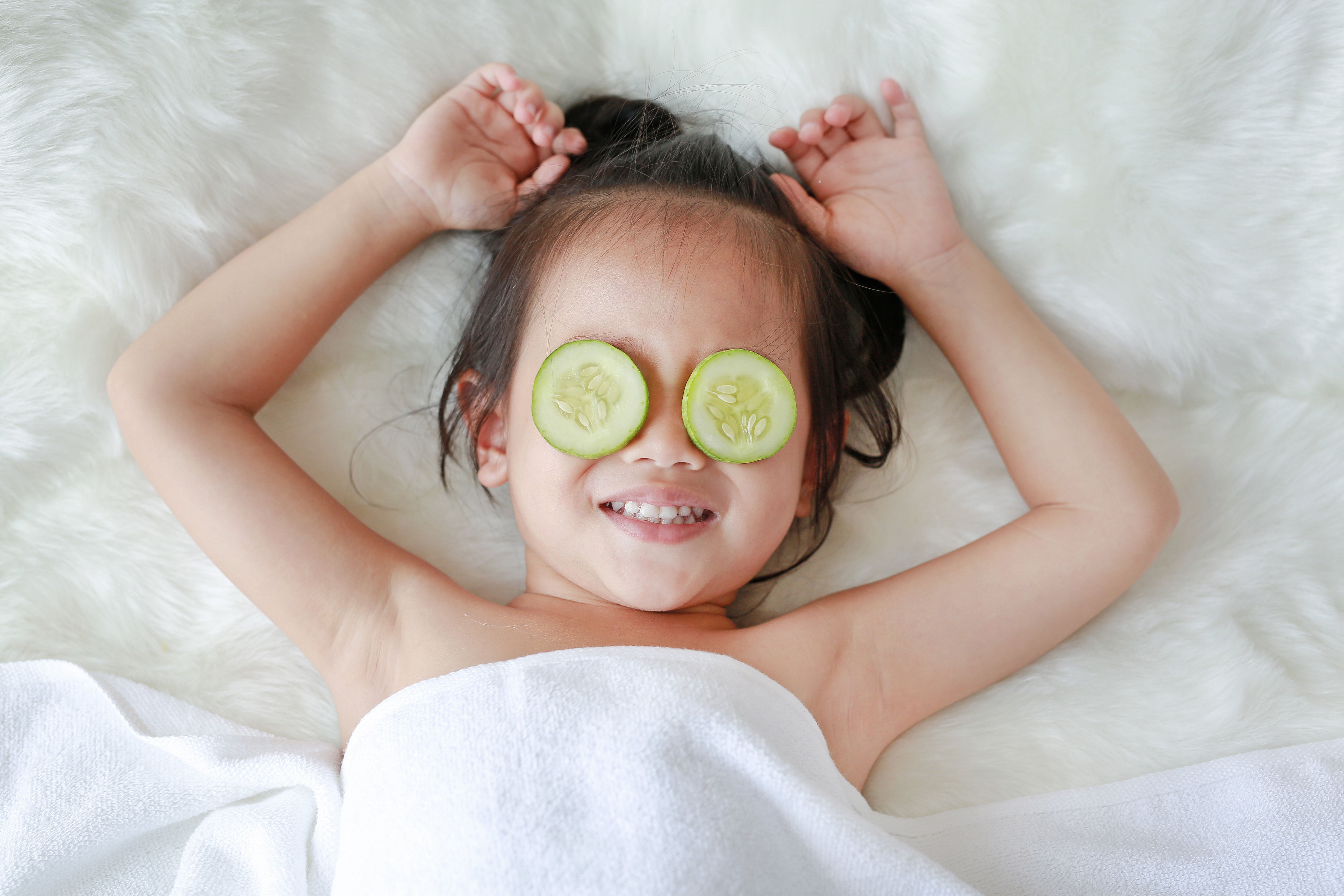 Baby with cucumber slices on eyes for rest and nourishment